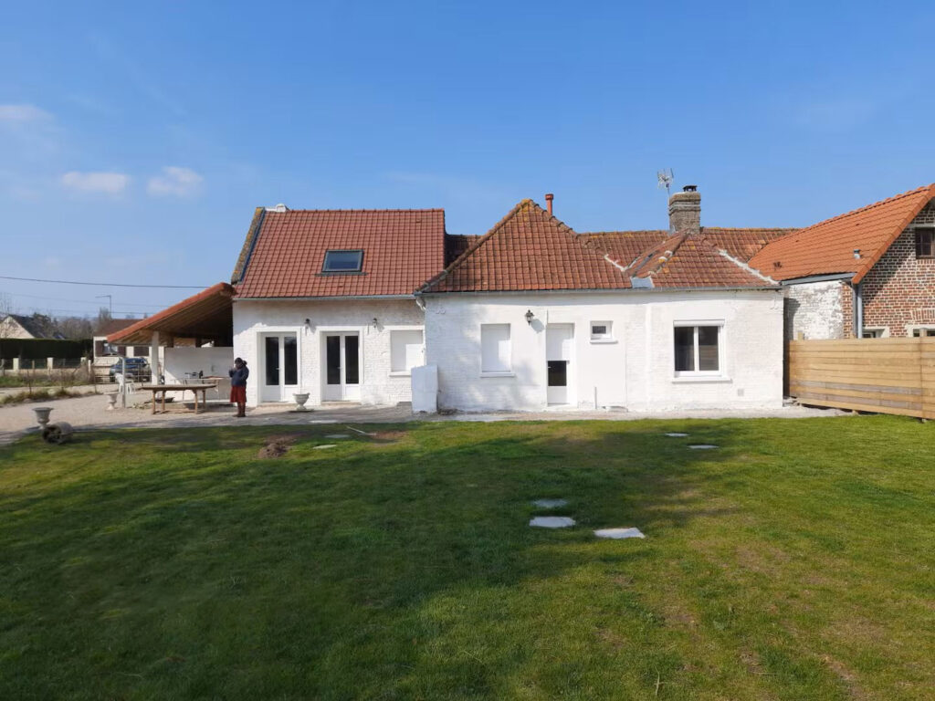 La maison vue du jardin: à gauche deux porte vitrées donnant dans le salon, au milieu une fenêtre et porte vitrée d'une chambre parentale, à droite une fenêtre d'une autre chambre parentale.