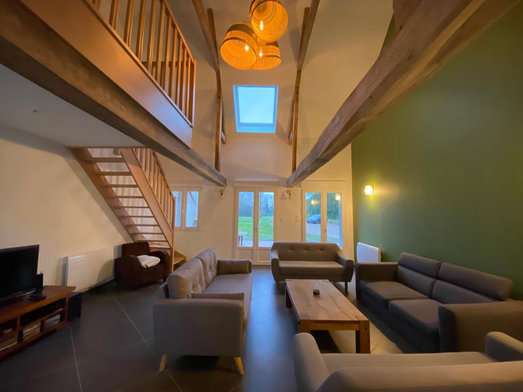 L'escalier du salon dessert deux chambres et une salle de bain. Une petite mezzanine est aménagée en coin lecture/jeu, avec un canapé et une table basse.